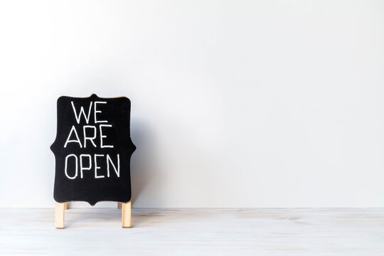 Blackboard with words WE ARE OPEN on white background