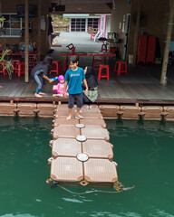 Kenyir, Malaysia - July 22, 2020: Aerial top view of family at the water chalet resort in Kenyir Lake, Terengganu, Malaysia.