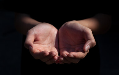 Two open empty hands wait holding something isolated on black background