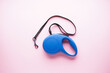 © VI Studio - Blue retractable dog leash on a pink background. Flat lay.
