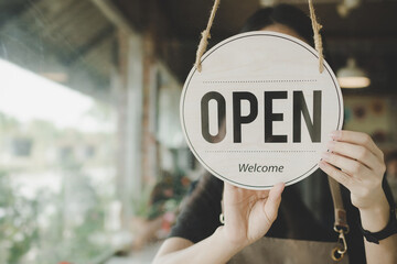 Welcome. Open. barista, waitress woman turning open sign board on glass door in modern cafe coffee shop ready to service, cafe restaurant, retail store, small business owner, food and drink concept