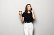 © dianagrytsku - Young business woman talking by mobile phone drinking coffee posing isolated over grey background