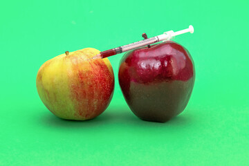 Syringe injection into a red apple. Genetic modified foods