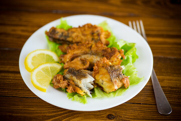 Wall Mural - fried hake fish in batter with lettuce and lemon in a plate