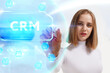 © photon_photo - Business, Technology, Internet and network concept. Young businessman working on a virtual screen of the future and sees the inscription: CRM