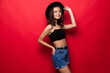 © dianagrytsku - Portrait of woman wearing in floppy hat and sunglasses isolated over red background