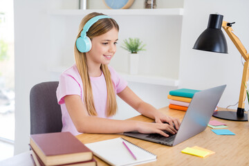 Canvas Print - Photo of small kid girl sit comfort cozy table desk study remote use laptop have online video call teacher communication texting typing have headset in house indoors