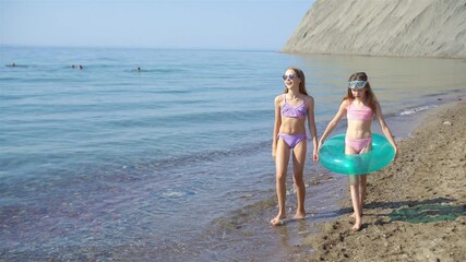 Sticker - Little happy funny girls have a lot of fun at tropical beach playing together.