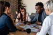 © Milles Studio/Stocksy - Professional multiethnic coworkers discussing project in conference room