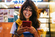 © Kike Arnaiz/Stocksy - Woman With Defocused Urban City Lights Looking At Her phone.