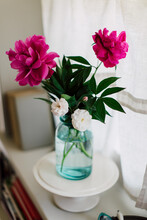 Tiny Roses And Pink Peonies In Blue Glass Jar On Windowsill Seen From Above