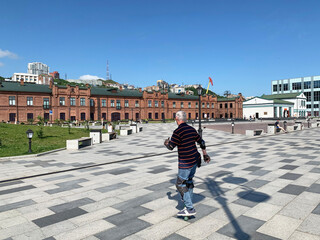 Poster -  Man rides on roller skates along Tsesarevich embankment in sunny day in Vladivostok