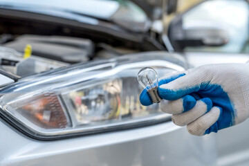 Professional worker changing new halogen light bulbs car