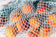 © Jen Grantham Photography/Stocksy - Close up on peaches in a net shopping bag