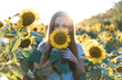 © Juliaap - Young beautiful woman smiling and having fun in a sunflower field on a beautiful summer day.