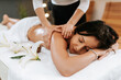 © mathefoto - Beautiful young woman in the massage salon with brown curly hair and healthy skin. Masseur and patient concept.