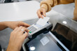 © Sergio Marcos/Stocksy - Detail of a client hands paying with a contactless card at a pharmacy