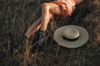 © Aleksandra Jankovic/Stocksy - Close Up Of Woman Lying In The Grass Next To Straw Sun Hat