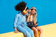 © BONNINSTUDIO/Stocksy - Delighted diverse friends listening to music and using smartphone