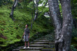 © ChaoShu Li/Stocksy - Photographer in travel, Standing on the stone steps in the woods