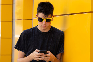 Poster - young teenager boy with mobile phone on the street