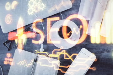Double exposure of SEO drawing over study table background with computer. Concept of search. Top view.