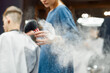 © Svitlana - Close up shot of a professional barber girl using hair powder while working in the modern barbershop