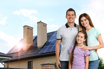 Happy family near their house with solar panels. Alternative energy source