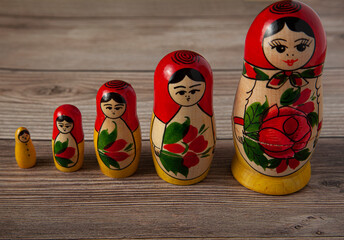 Wall Mural - A line up of handmade Russian Matrushka dolls on wooden background. These folkloric women figurines are famous in Slavic countries and these toys are popular souvenirs for tourists visiting there.