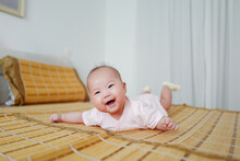 Portrait Of Cute Baby Lying On Bed At Home