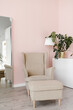 © Alina Hvostikova/Stocksy - Modern pink interior with mirror and beige chairs for relax.
