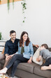 © Lauren Edmonds/Stocksy - Young Family Laughing Together in Modern Home