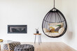 © Lauren Edmonds/Stocksy - Hanging Chair in Bright, Bohemian Living Room