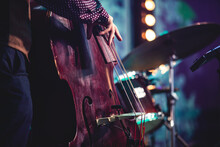 Concert View Of A Contrabass Violoncello Player With Vocalist And Musical During Jazz Orchestra Band Performing Music, Violoncellist Cello Player On Stage
