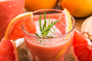 Wall Mural - Grapefruit juice with rosemary and ice in a glass on the table. Refreshing summer cocktail