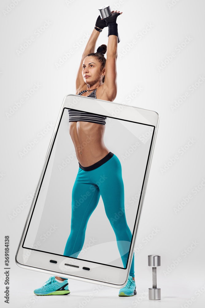 Beautiful muscular female body photographed on modern smartphone. conceptual collage with device