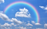 Fototapeta Tęcza - Abstract rainbow on beautiful blue sky and white clouds as background and wallpaper. 