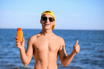 Sticker - Handsome young man with sunscreen cream on sea beach