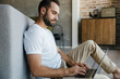 © Drobot Dean - Image of young thinking man working with laptop while sitting on floor