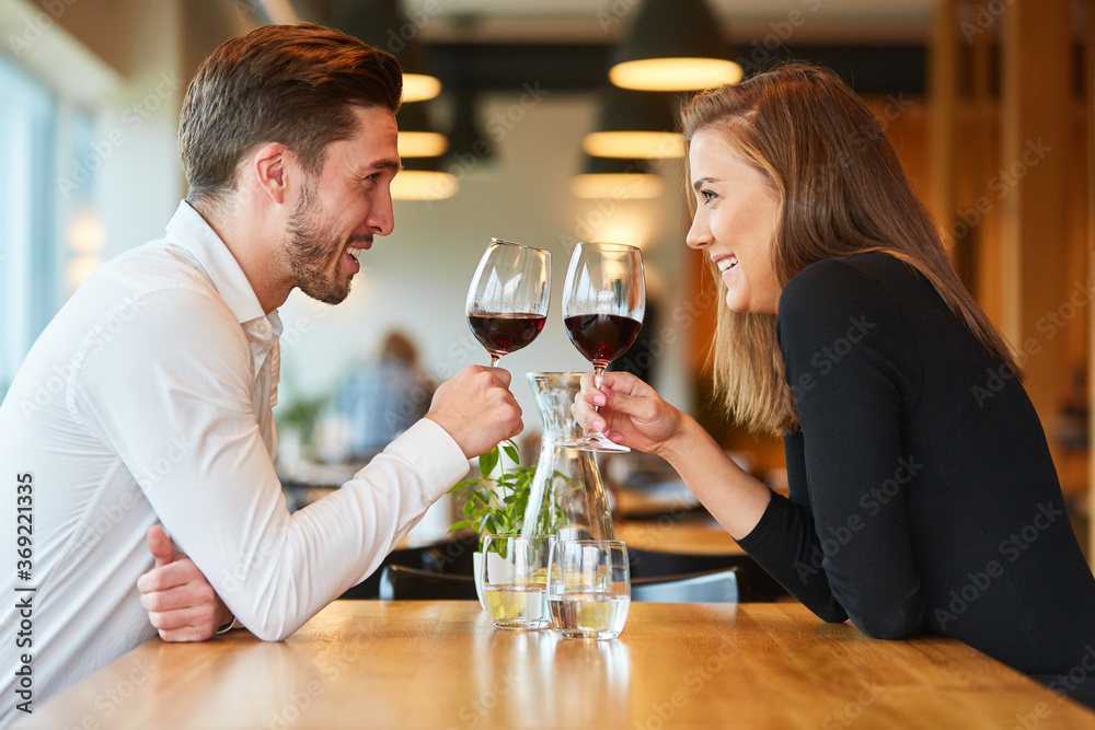 Couple in love drinking wine in the restaurant - obrazy, fototapety, plakaty 