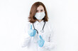 © Volha - Smart young asian woman doctor in lab coat with Medical face mask,white latex medical gloves and stethoscope against blue background,health care concept