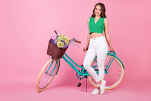 Full Length Profile Side Photo Of Positive Cheerful Girl Sit Leather Bicycle Saddle Enjoy Travel Field Trip Collect Wildflowers Basket Wear Green White Outfit Isolated Over Pastel Color Background