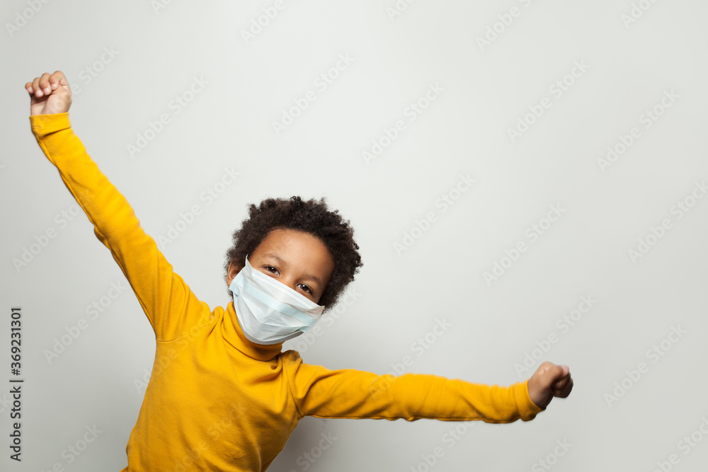 Portrait of funny black child boy in medical protective face mask having fun - obrazy, fototapety, plakaty 