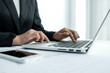 © Orathai - The hands of a male businesswoman are analyzing and calculating the annual income and expenses in a financial graph that shows results To summarize balances overall in office