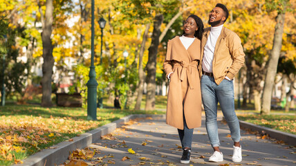 Beautiful romantic black couple walking in city park and enjoying nature