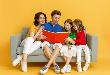 Wall Mural - Happy loving family on bright color background.