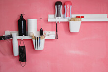 White Shelves With Bottles And Tools On A Pink Wall In A Beauty Salon