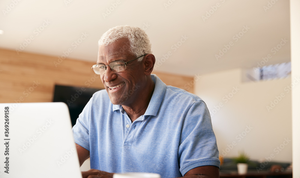 Senior African American Man Using Laptop To Check Finances At Home - obrazy, fototapety, plakaty 