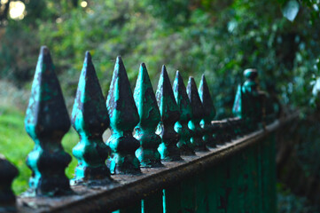 green cast iron fence with pointy end with some parts in focus