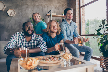 Portrait of four nice attractive cheerful cheery guys meeting watching match game sport world cup rest relax having fun at industrial loft style interior house apartment flat indoors